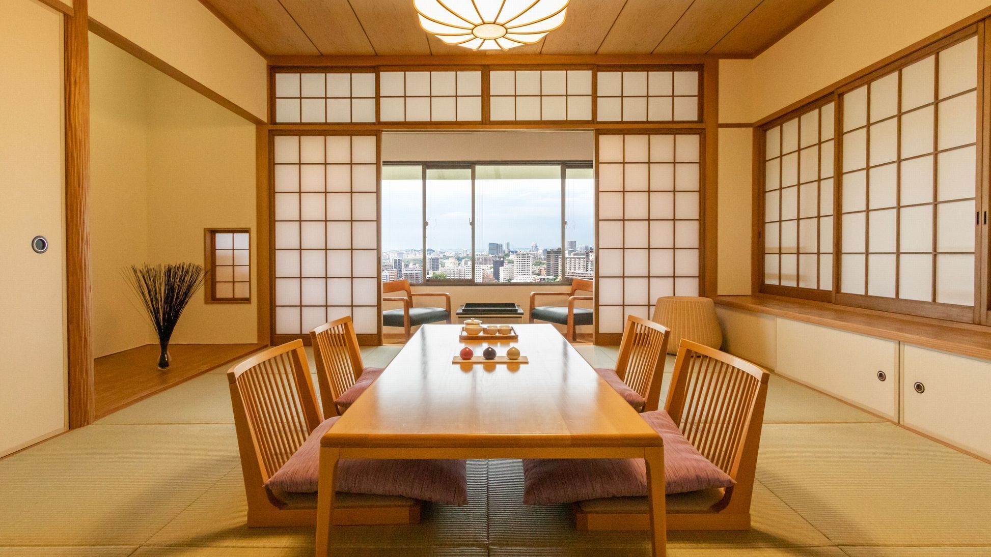 Una habitación japonesa tradicional con suelo de tatami, una mesa baja y puertas correderas.