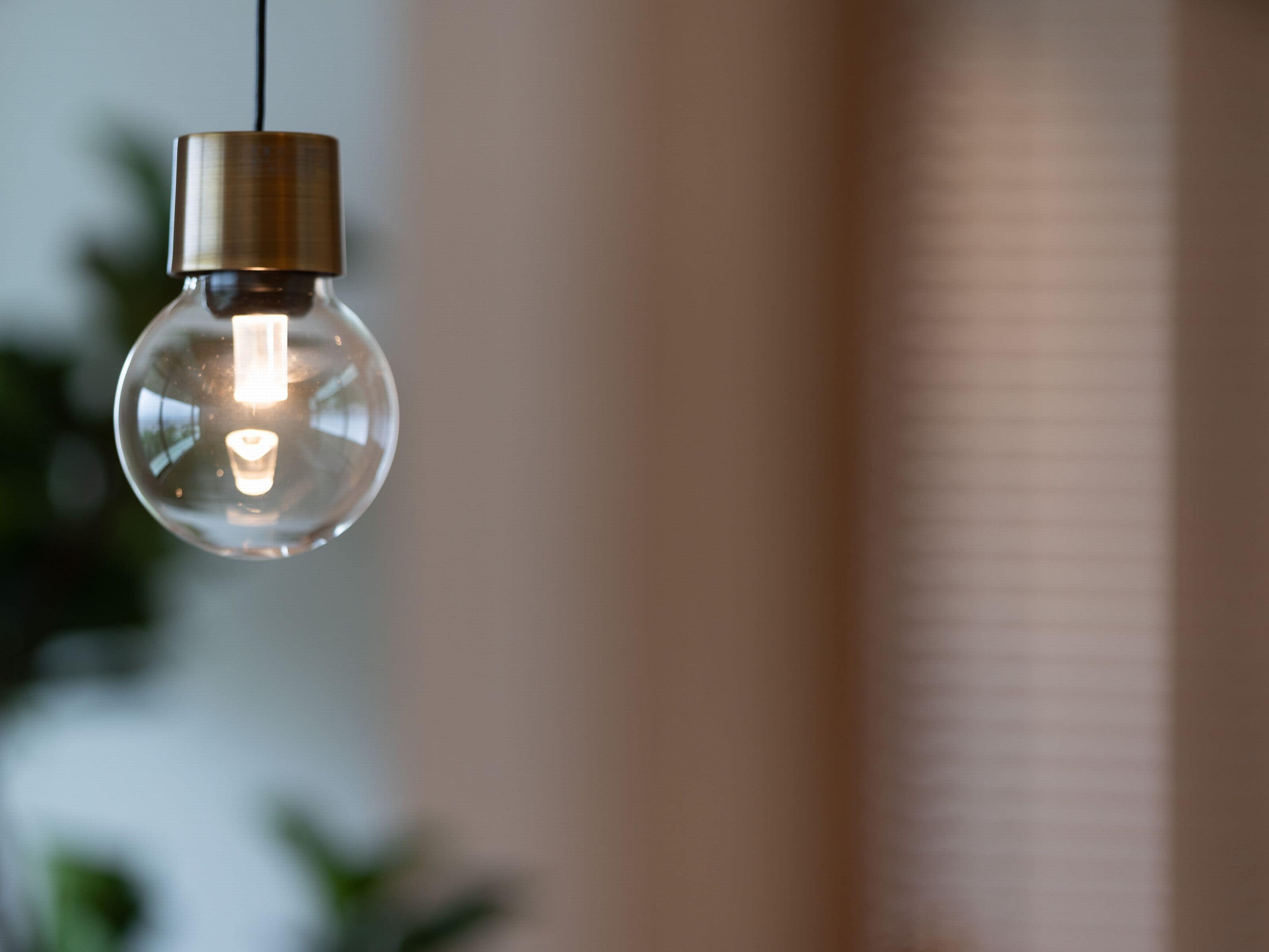 A clear glass light bulb hanging from a cord.