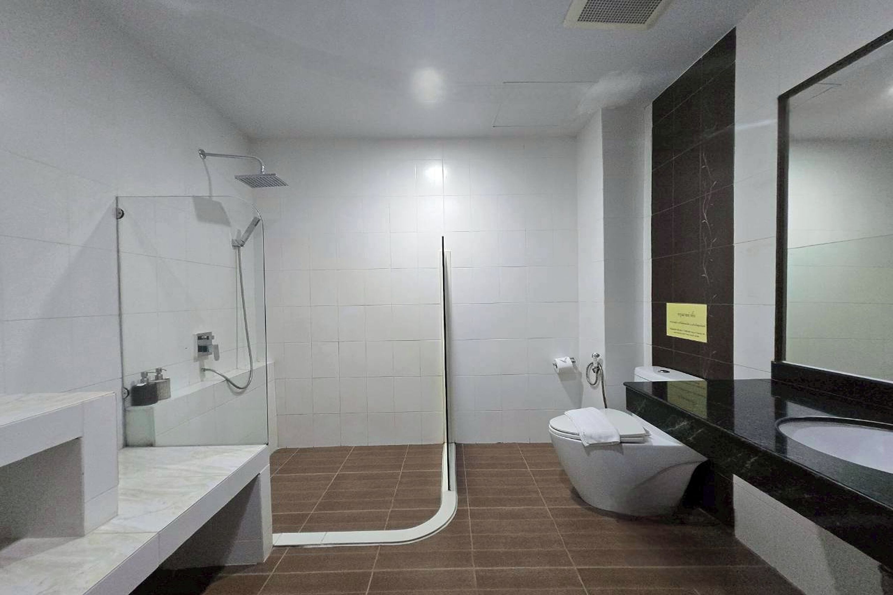 A modern bathroom with a shower, toilet, and sink.
