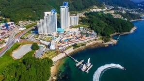 A coastal resort with multiple high-rise buildings, a marina, and a winding road.