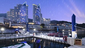 Un hôtel situé au bord de l’eau, doté d’une architecture moderne, d’un quai et dont l’image se reflète dans l’eau.
