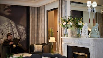 Una sala de estar elegante con chimenea, asientos cómodos y estatuas decorativas.