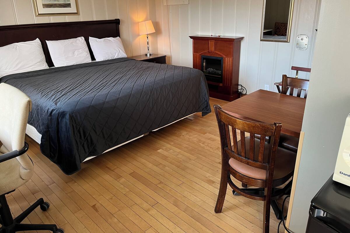 Une chambre d’hôtel équipée d’un lit, d’un bureau, d’une chaise, d’une lampe et d’une cheminée.