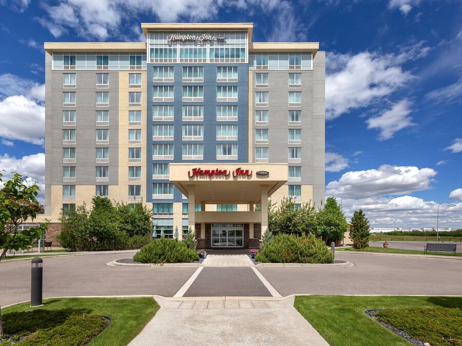 A Hampton Inn hotel with a modern facade, multiple floors, and a central entrance.