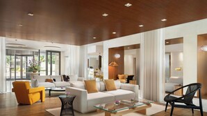 A modern living room with a sofa set, a glass coffee table, and a yellow armchair. - Renaissance Aix-en-Provence Hotel (Aix-en-Provence)