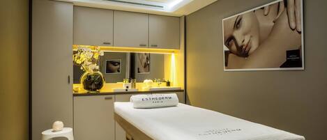 A modern bedroom with a bed, a vanity with a mirror, and a small stool.