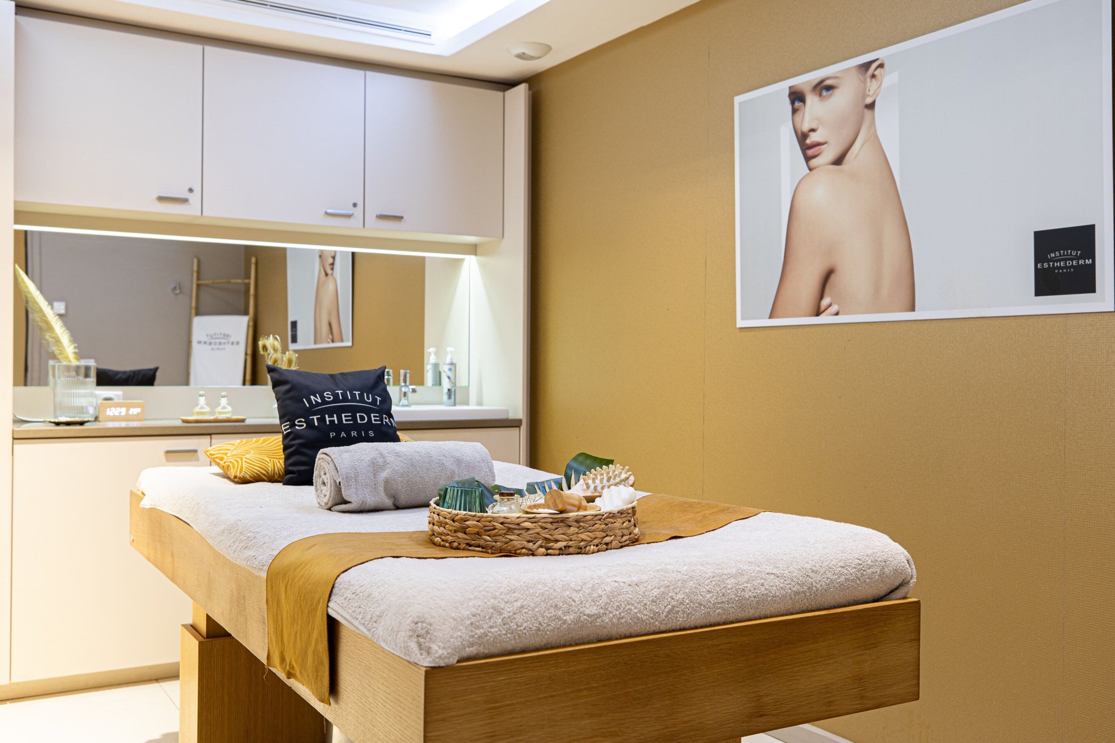 Un spa moderno con una camilla de madera para masajes, un espejo y un cartel en la pared.