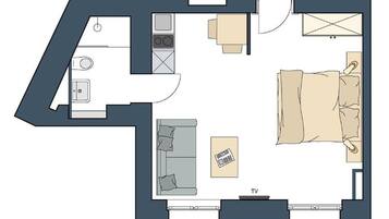 A bedroom with a bed, TV, and a small table.