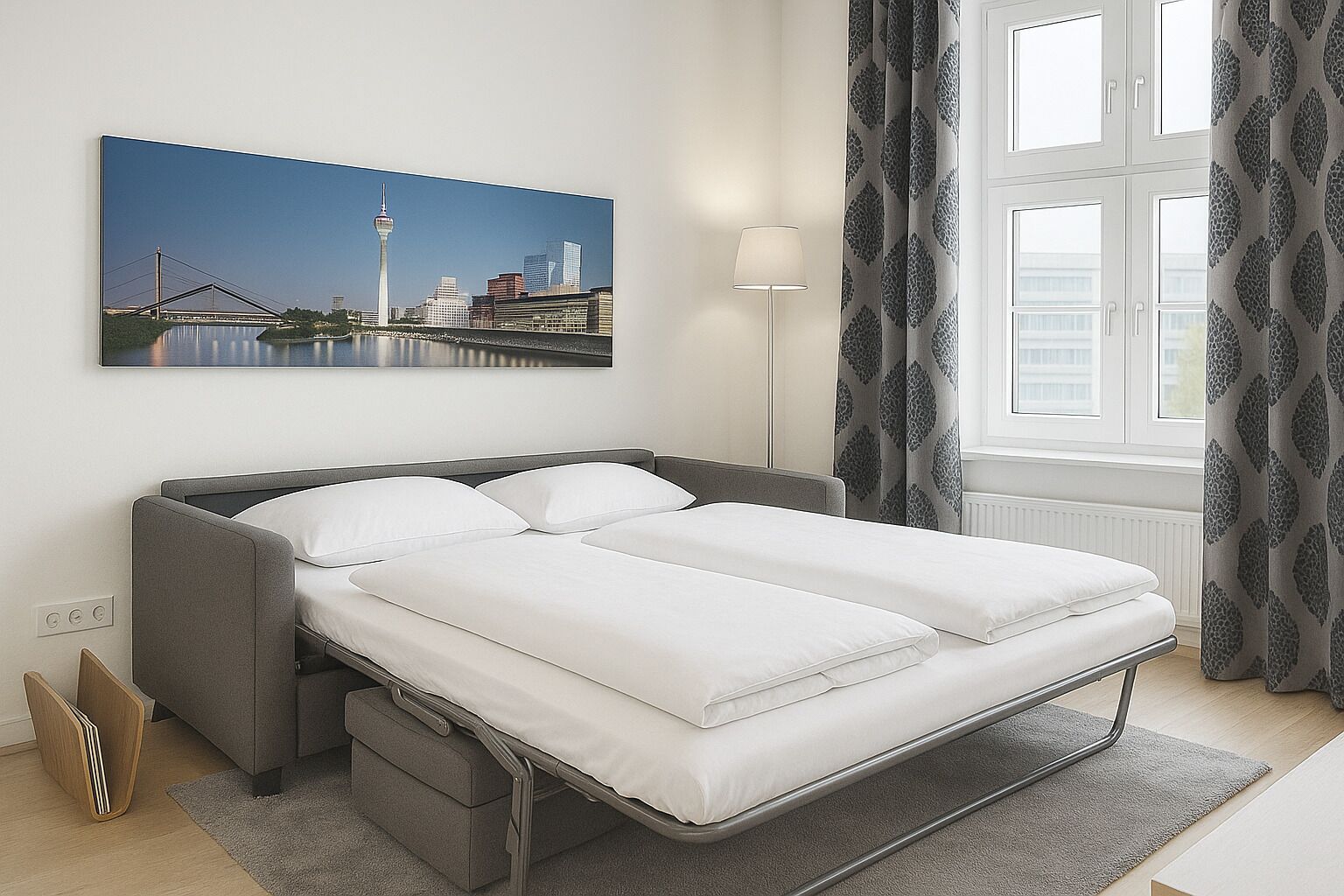 Ett modernt hotellrum med en säng, ett nattduksbord, en lampa och utsikt över stadsbilden.