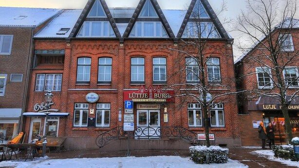 Un bâtiment en briques sur lequel on peut lire l’enseigne « Lüttje Burg Hotel & Restaurant ».