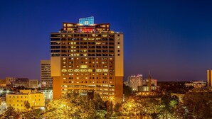Ein Hochhaus-Hotel mit mehreren Etagen, beleuchteten Fenstern und einer auffälligen Schilderung im oberen Bereich.