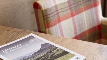 A brochure titled "Momente im Kufsteinland" on a wooden table.