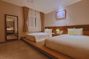 A hotel room with two beds, a large mirror, a nightstand with a lamp, and a painting on the wall. - Cherry Boutique Hotel (Ho Chi Minh City)