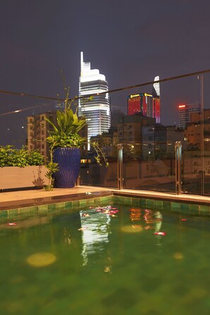A rooftop pool with a view of a city skyline at night. - Cherry Boutique Hotel (Ho Chi Minh City)