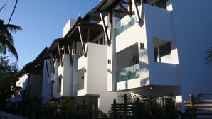 A multi-story hotel with balconies, a flat roof, and a modern architectural style. - Dodola Lodge (Grand-Baie)