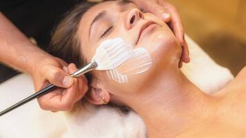 A person receiving a facial treatment with a brush.