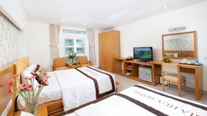 Una habitación de hotel con cama, escritorio, televisión y armario.