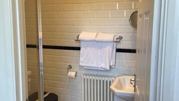 A bathroom with a black and white checkered floor, a white toilet, a white sink, and a towel rack with two towels.