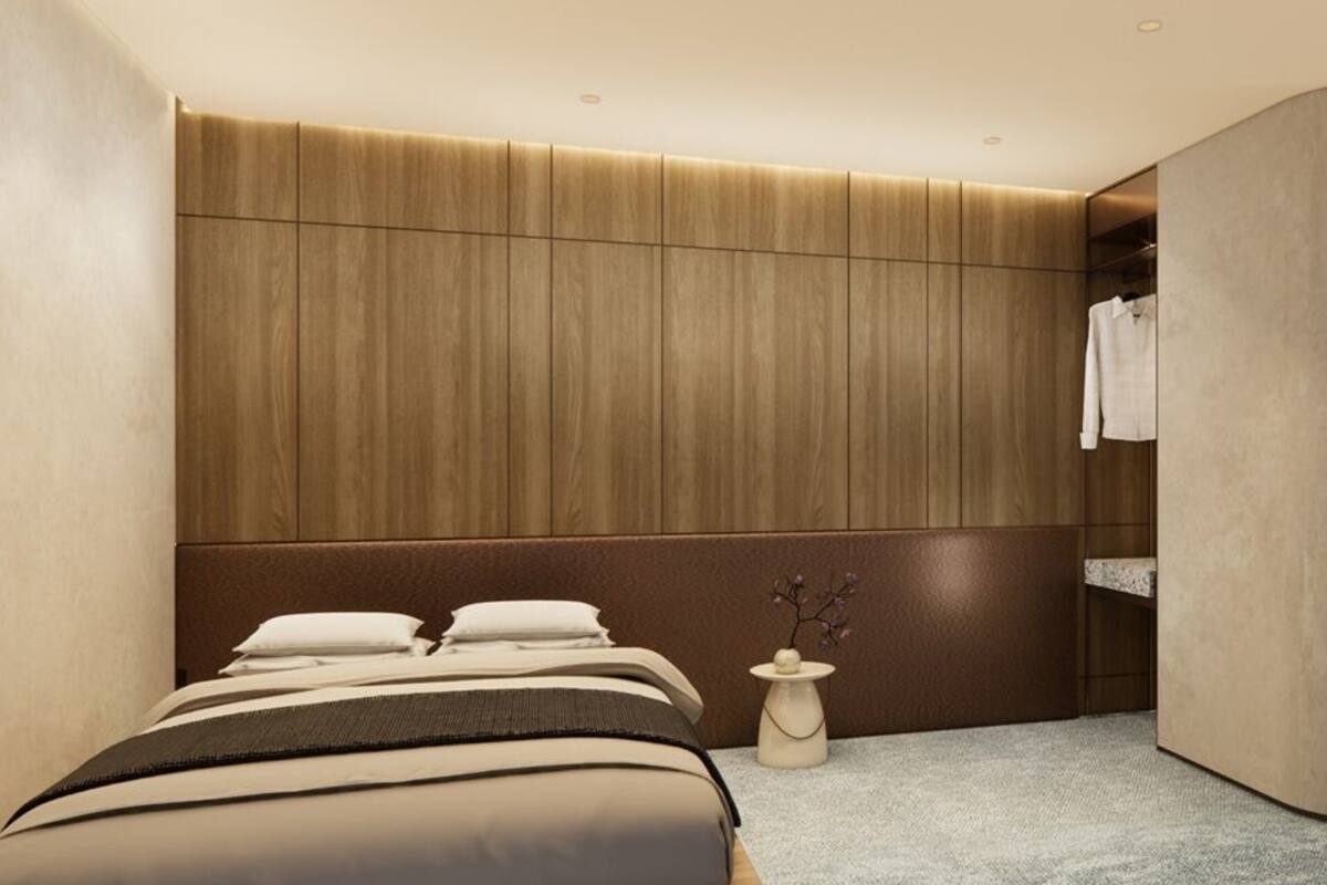 A modern hotel room with a bed, a vanity with a mirror, and a walk-in closet.