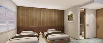 A modern hotel room with two beds, a wooden headboard, a small table with a vase, and a bathroom visible through an open door.