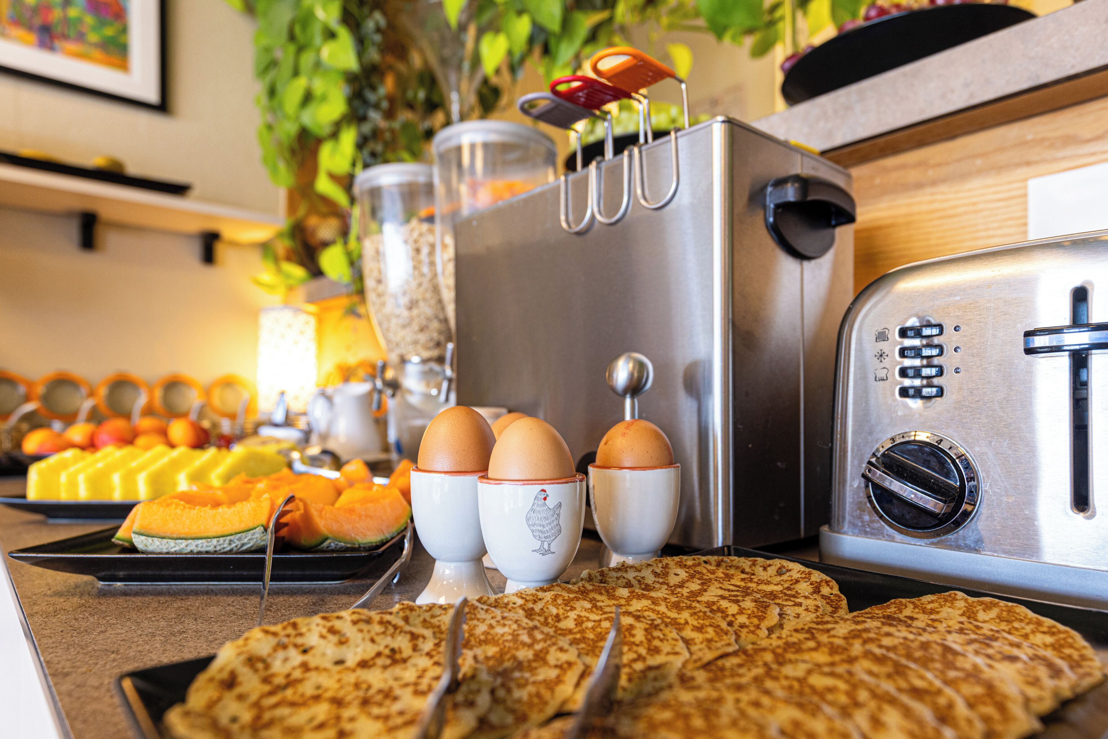 Un buffet de petit-déjeuner proposant une variété d'aliments, notamment des œufs, des toasts et des fruits.