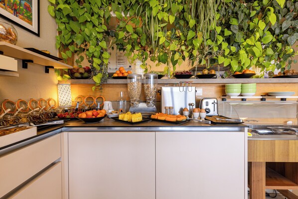Cocina con una exhibición de frutas, un lavamanos y un microondas.