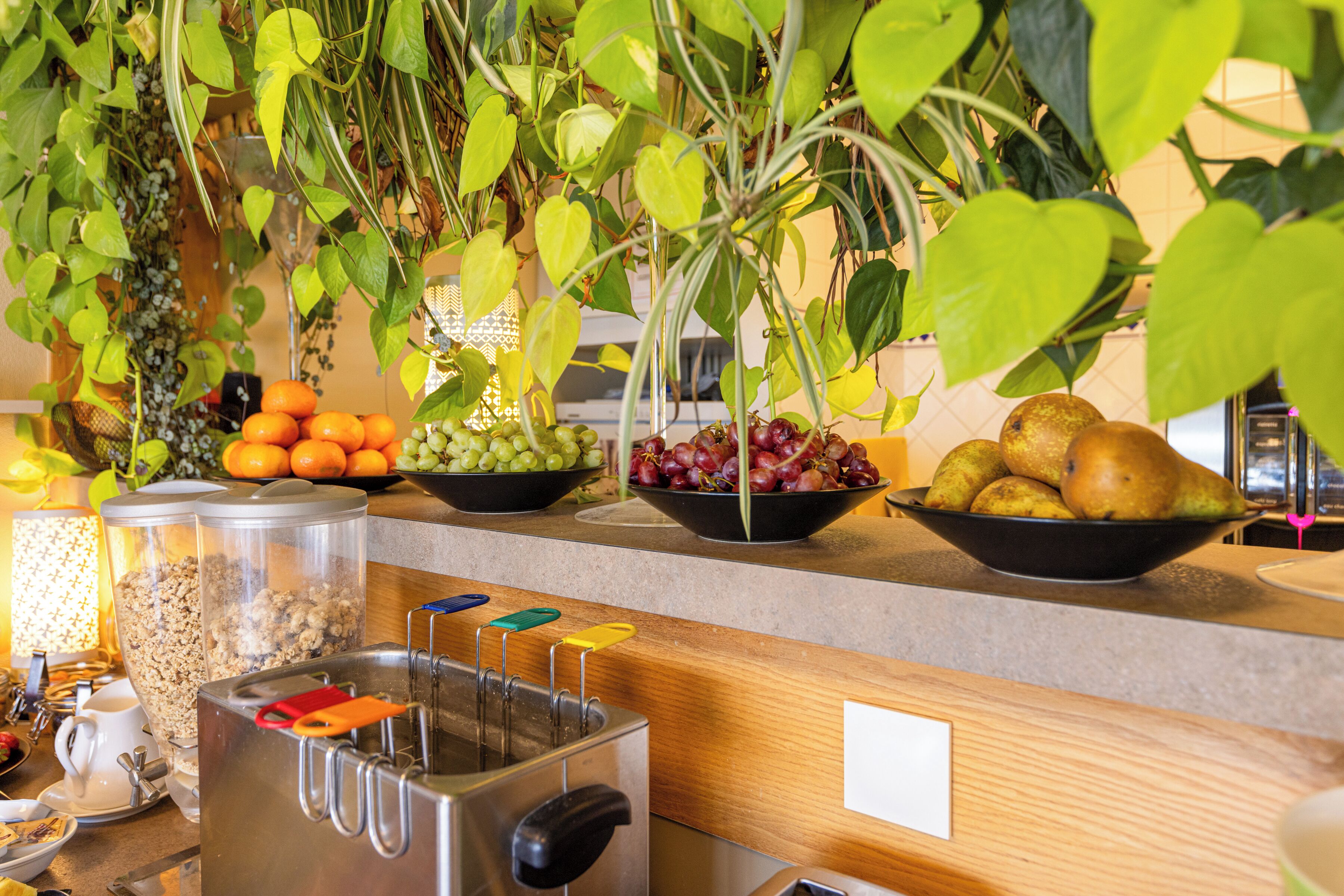 A kitchen counter with various fruits, a toaster, and a coffee machine.