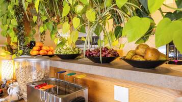A kitchen counter with various fruits, a toaster, and a coffee machine.
