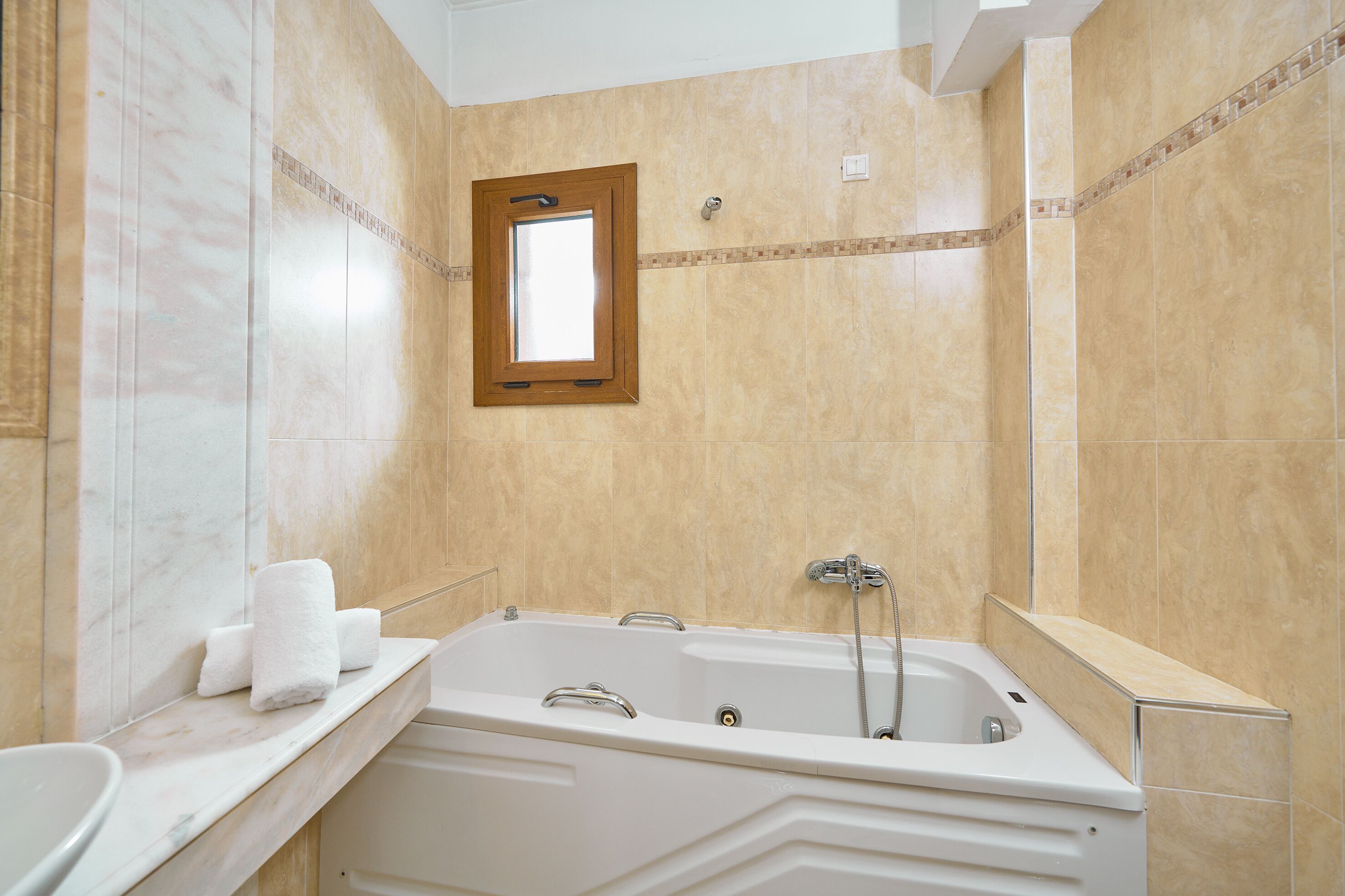 A bathroom with a bathtub, a mirror, and a towel rack.