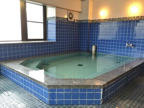 A rectangular hot tub with a tiled blue interior and a granite border, located in a room with similar blue tiles on the walls and floor. - Hotel Asyl Nara Annex (Nara)