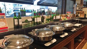 A buffet setup with multiple stainless steel serving pots, a digital scale, and a variety of wine bottles on display. - Hotel Asyl Nara Annex (Nara)