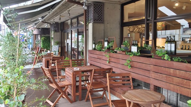 An outdoor seating area with wooden tables and chairs, a covered patio, and potted plants. - Hotel Asyl Nara Annex (Nara)