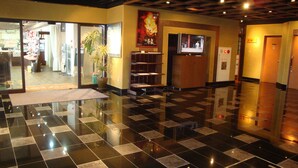 A lobby with a checkered floor, a reception desk, a television, and a plant. - Hotel Asyl Nara Annex (Nara)