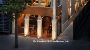 Hotel Montefiore 16 - een stadsboetiekhotel met een modern design, met een balkon met zitplaatsen en een trap naar een hoger gelegen niveau.
