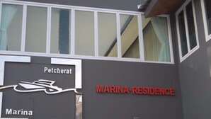 Un edificio con señalización que indica 'Marina-Residence' y 'Petcherat'.