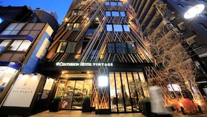 The exterior of Centurion Hotel Vintage with a modern architectural design, featuring a prominent entrance and illuminated signage. - Centurion Hotel Grand Akasaka (Tokyo)