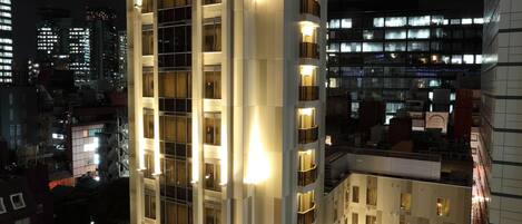 A high-rise hotel with multiple floors, illuminated windows, and a modern architectural design.