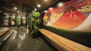 A lobby with a wooden bench, potted plants, and a mural of a mountain. - Centurion Hotel Grand Akasaka (Tokyo)