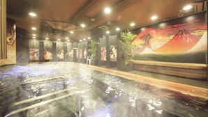 A hot spring bath with steam rising, surrounded by wooden pillars and a mural of a mountain scene. - Centurion Hotel Grand Akasaka (Tokyo)