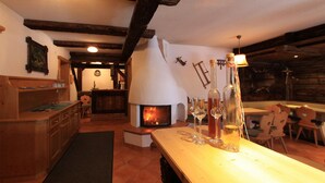 Un intérieur rustique avec une cheminée en pierre, des meubles en bois et un coin repas.