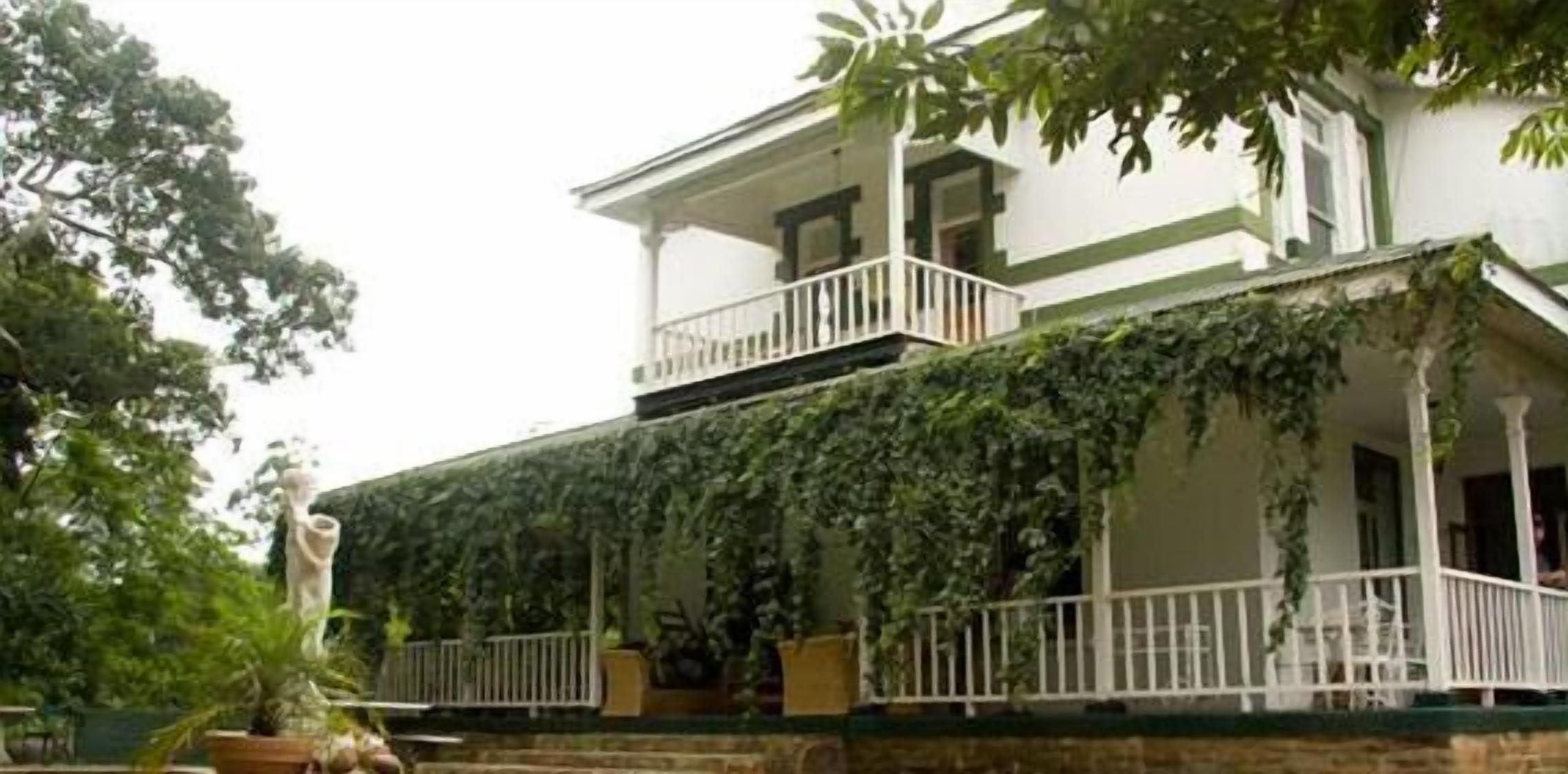 Un edificio de dos plantas con un balcón y un porche cubierto.