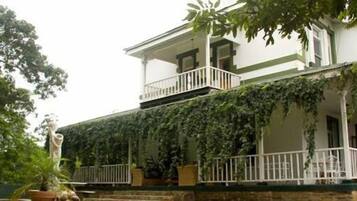 Un edificio de dos plantas con un balcón y un porche cubierto.