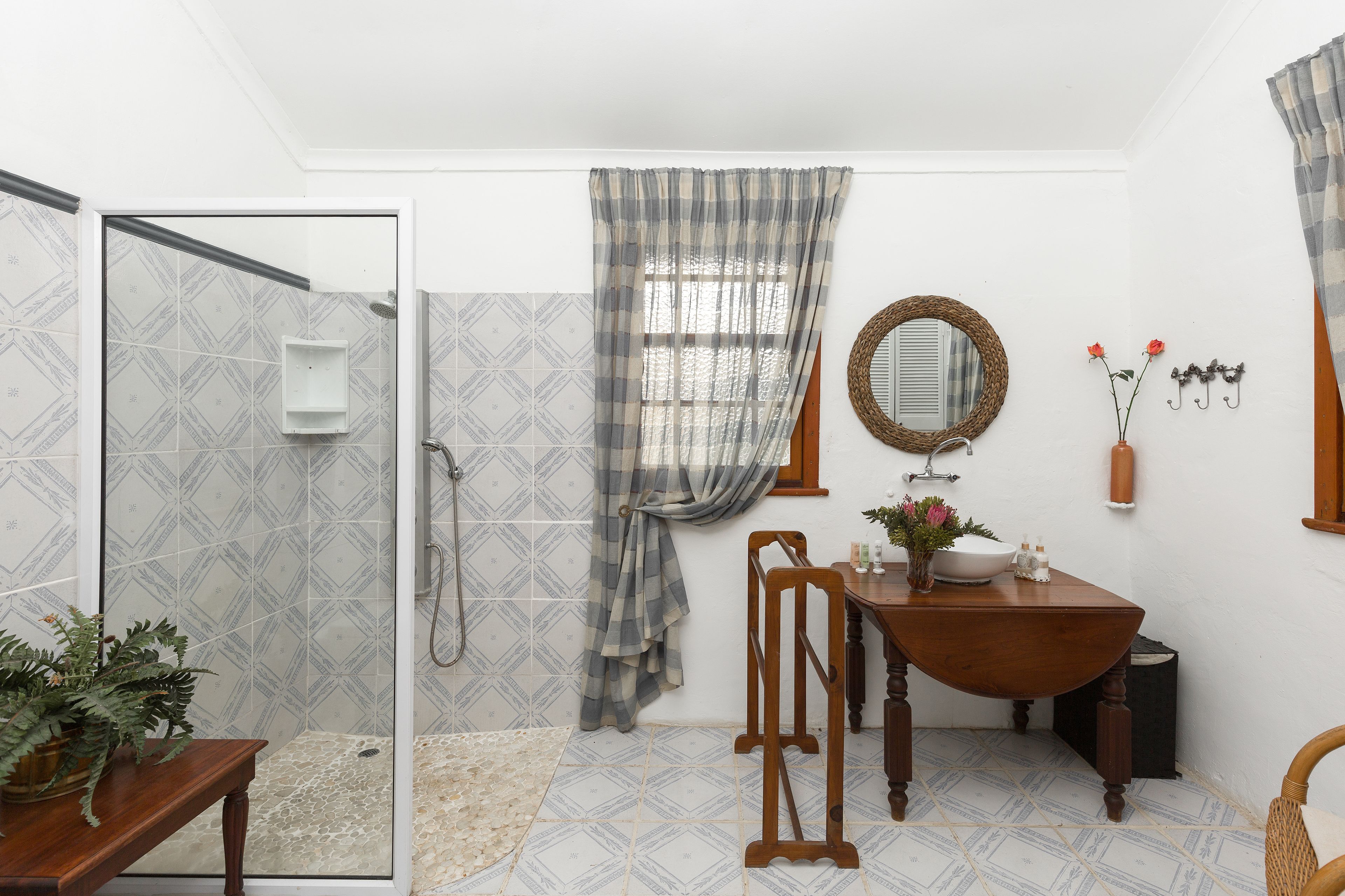 A bathroom with a shower, a sink, and a mirror.