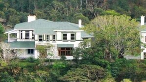 A large, two-story house with a green roof, surrounded by dense greenery. - Royston Hall Guesthouse (Port Shepstone)