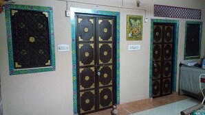 Un couloir avec de nombreuses portes, chacune ornée de motifs décoratifs et d’étiquettes.