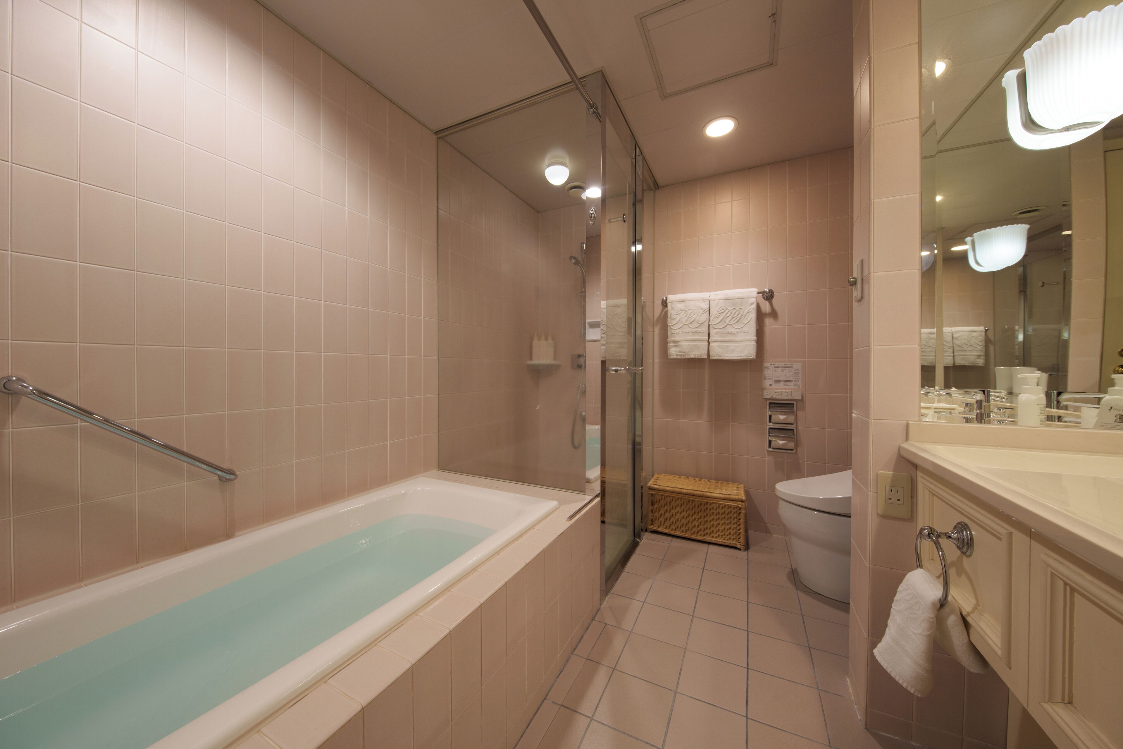 Un bagno moderno con doccia vetrata, vasca e WC.