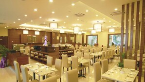 Ein geräumiges Restaurant mit mehreren Tischen und Stühlen, einer zentralen Theke und einem modernen Interieur.