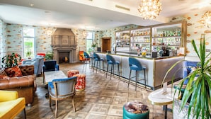 Amplia sala de estar con chimenea, asientos cómodos y un bar con gran variedad de botellas.