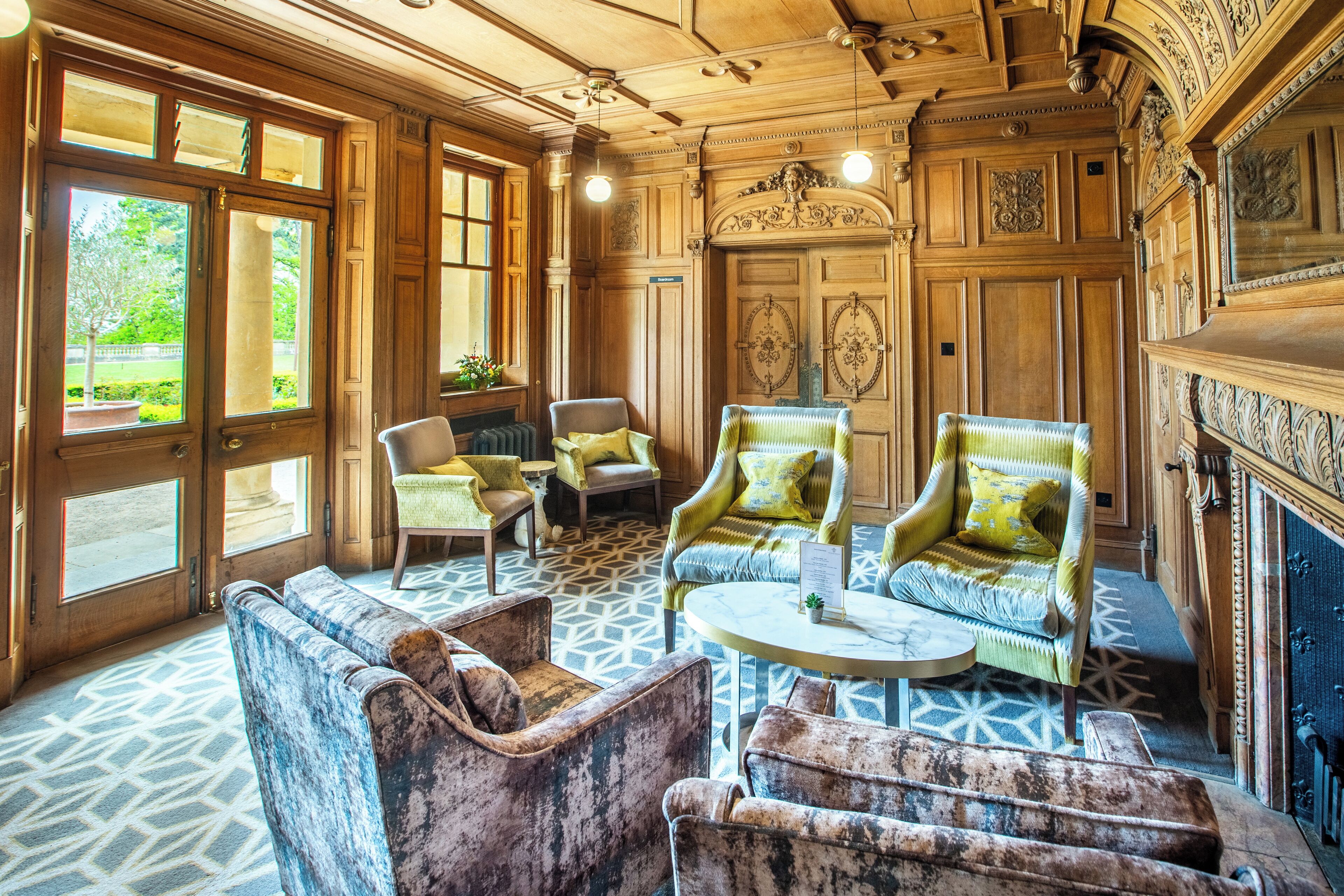 A room with a large window, a fireplace, and a patterned floor.