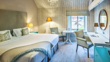 A hotel room with a large bed, a desk, a chair, and a view of the outside.
